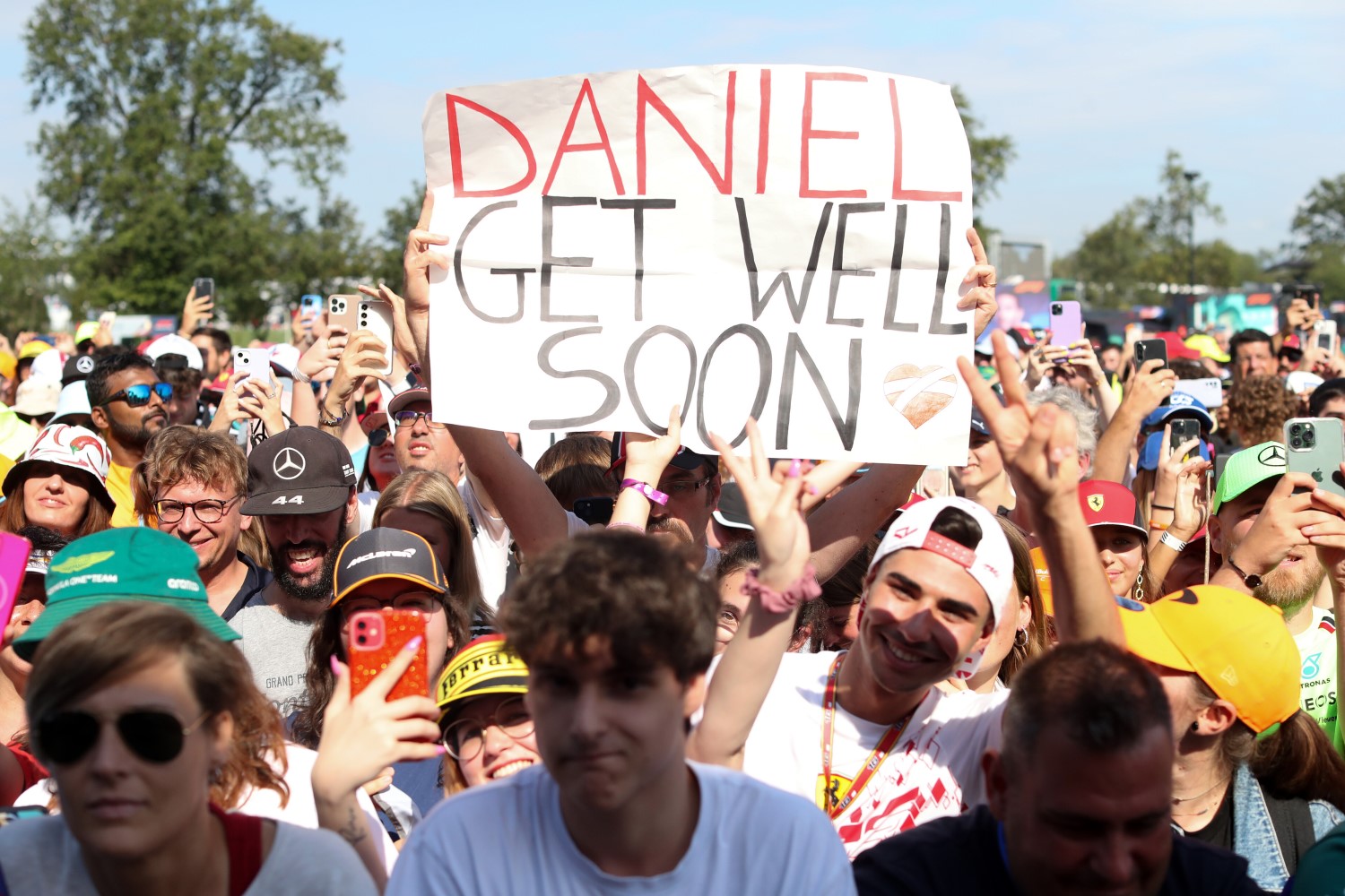 A fan holds a sign wishing the injured Daniel Ricciardo of Australia and Scuderia AlphaTauri well prior to practice ahead of the F1 Grand Prix of Italy at Autodromo Nazionale Monza on September 01, 2023 in Monza, Italy. (Photo by Peter Fox/Getty Images) // Getty Images / Red Bull Content Pool