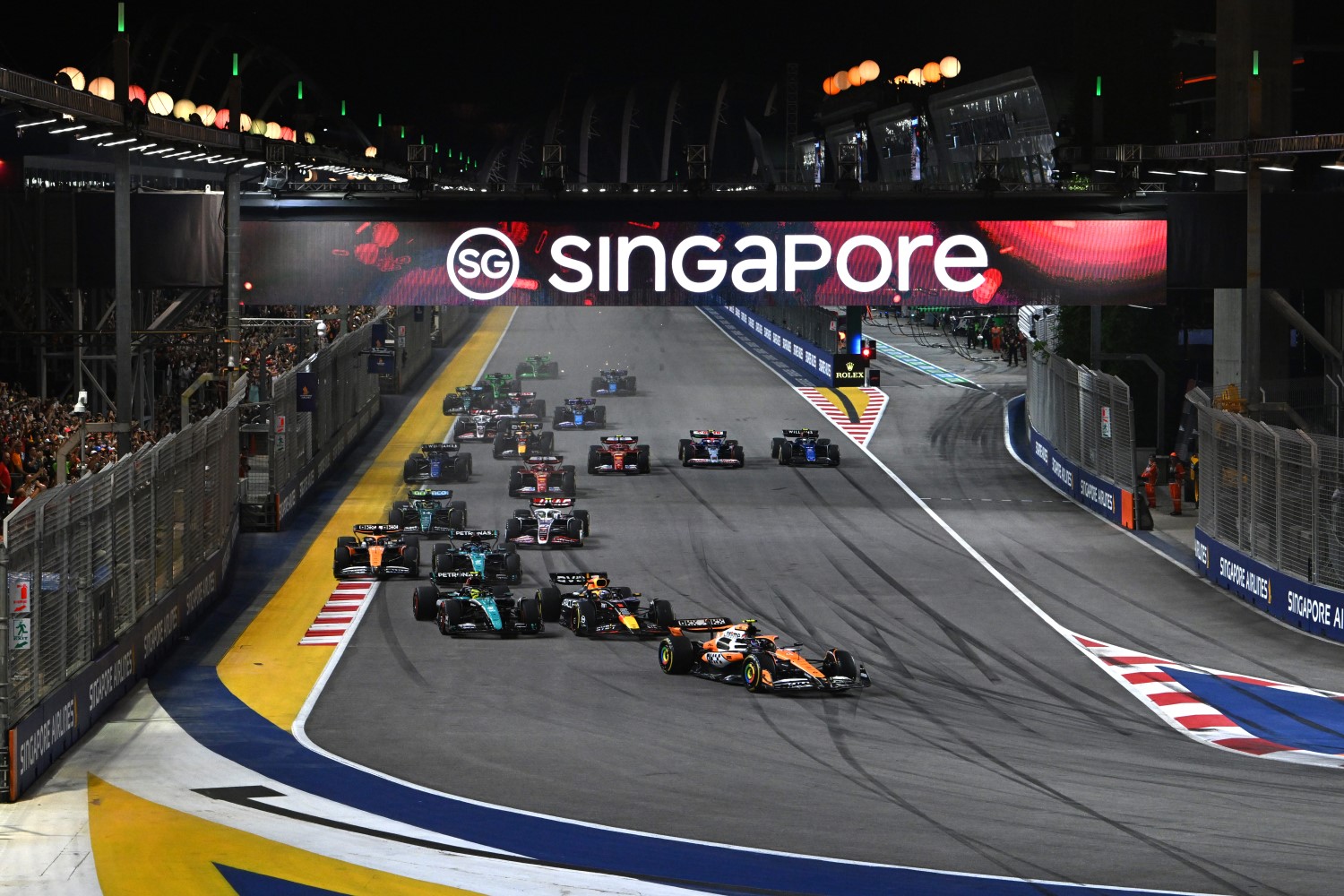 Lando Norris, McLaren MCL38, leads Max Verstappen, Red Bull Racing RB20, Sir Lewis Hamilton, Mercedes F1 W15