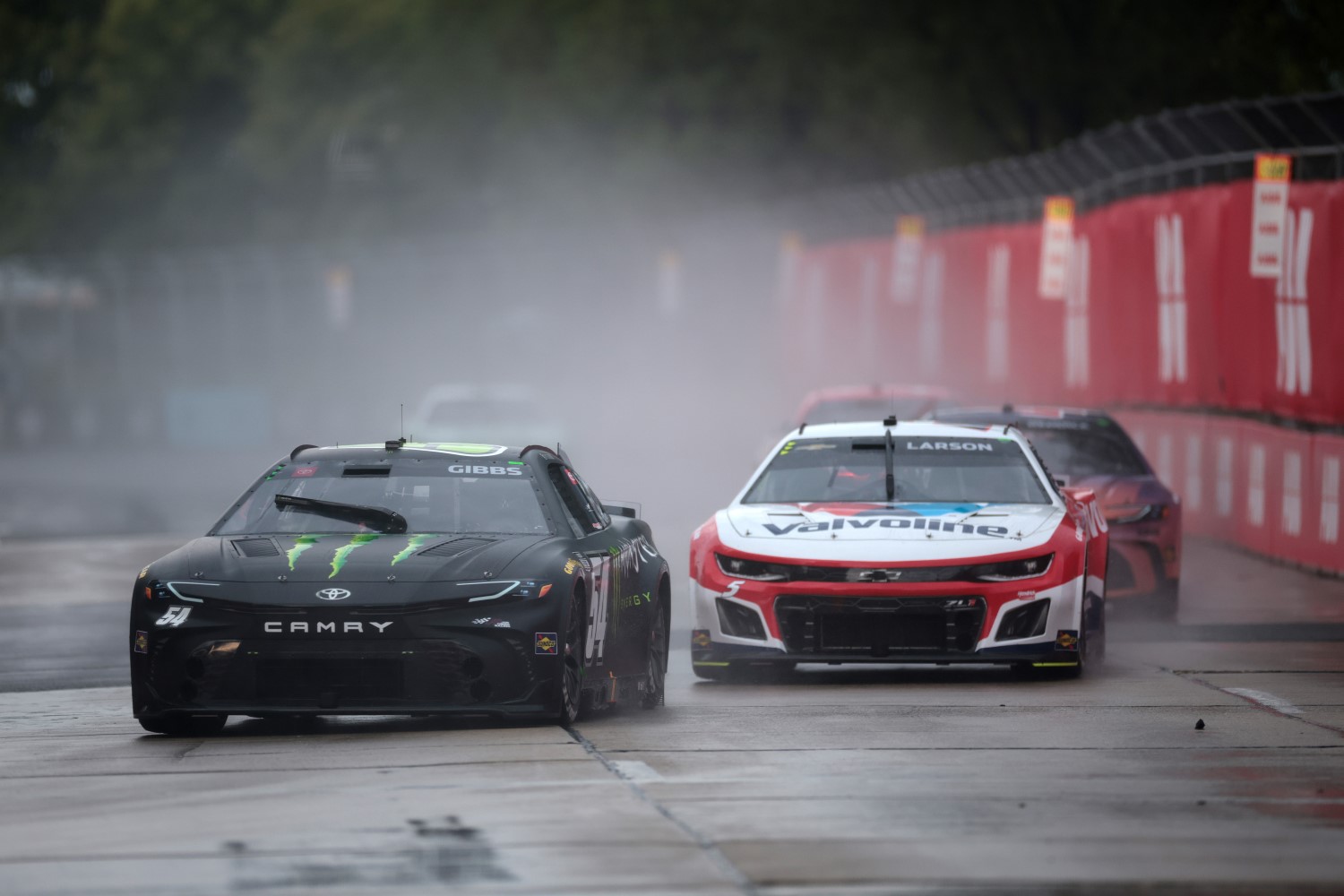 Ty Gibbs, driver of the #54 Monster Energy Toyota, and Kyle Larson, driver of the #5 Valvoline Chevrolet, race during the NASCAR Cup Series Grant Park 165 at Chicago Street Course on July 07, 2024 in Chicago, Illinois. (Photo by James Gilbert/Getty Images)