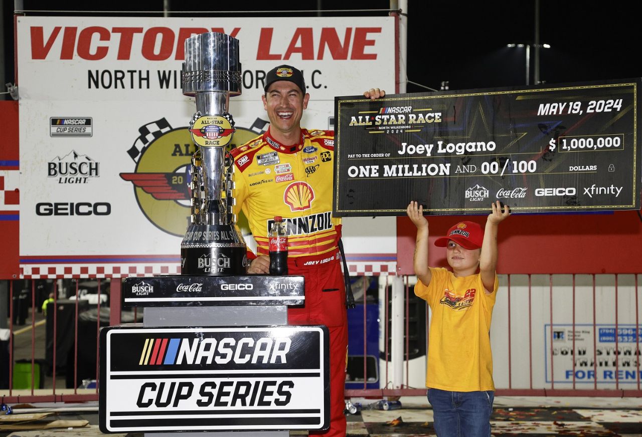 Joey Logano, driver of the #22 Shell Pennzoil Ford, celebrates with the one million dollar check in victory lane after winning the NASCAR Cup Series All-Star Race at North Wilkesboro Speedway on May 19, 2024 in North Wilkesboro, North Carolina. (Photo by Sean Gardner/Getty Images for NASCAR)